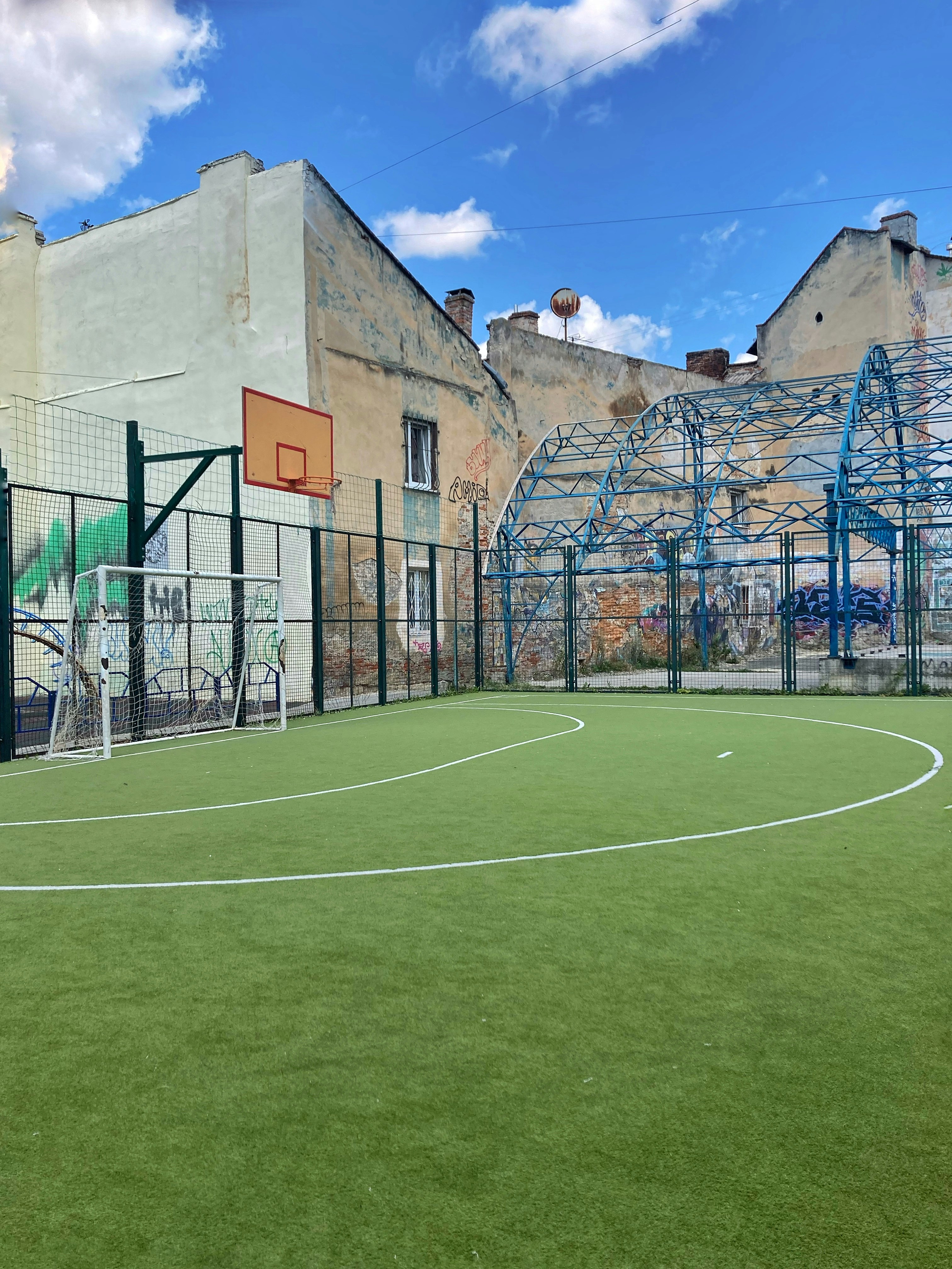 green soccer field near brown concrete building during daytime